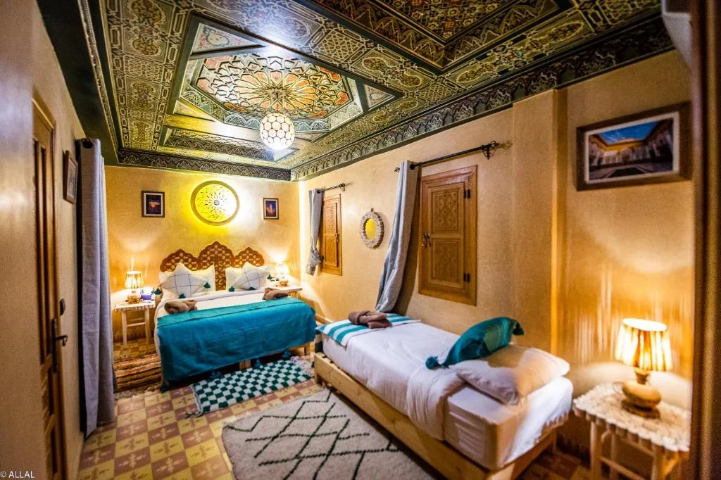 Deluxe triple room with ornate Moroccan ceiling at Riad Almonds Marrakech