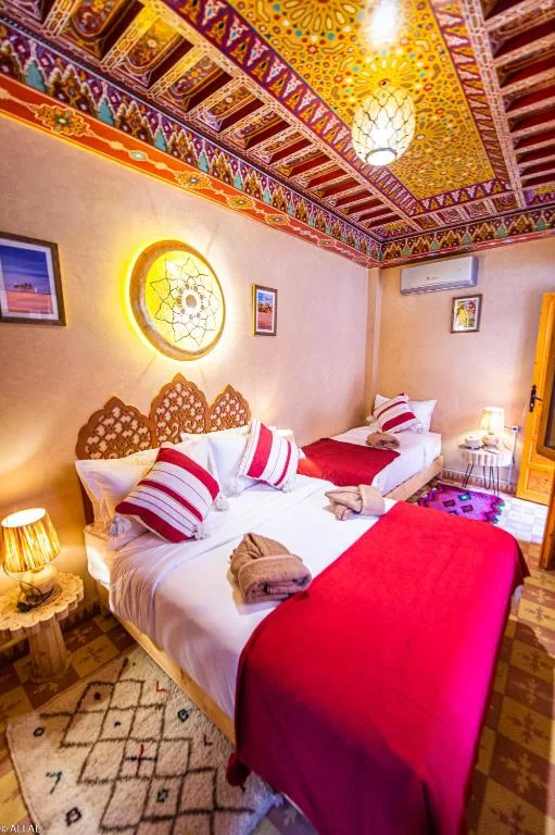 Guest room with red bedding and traditional decor at Riad Almonds Marrakech